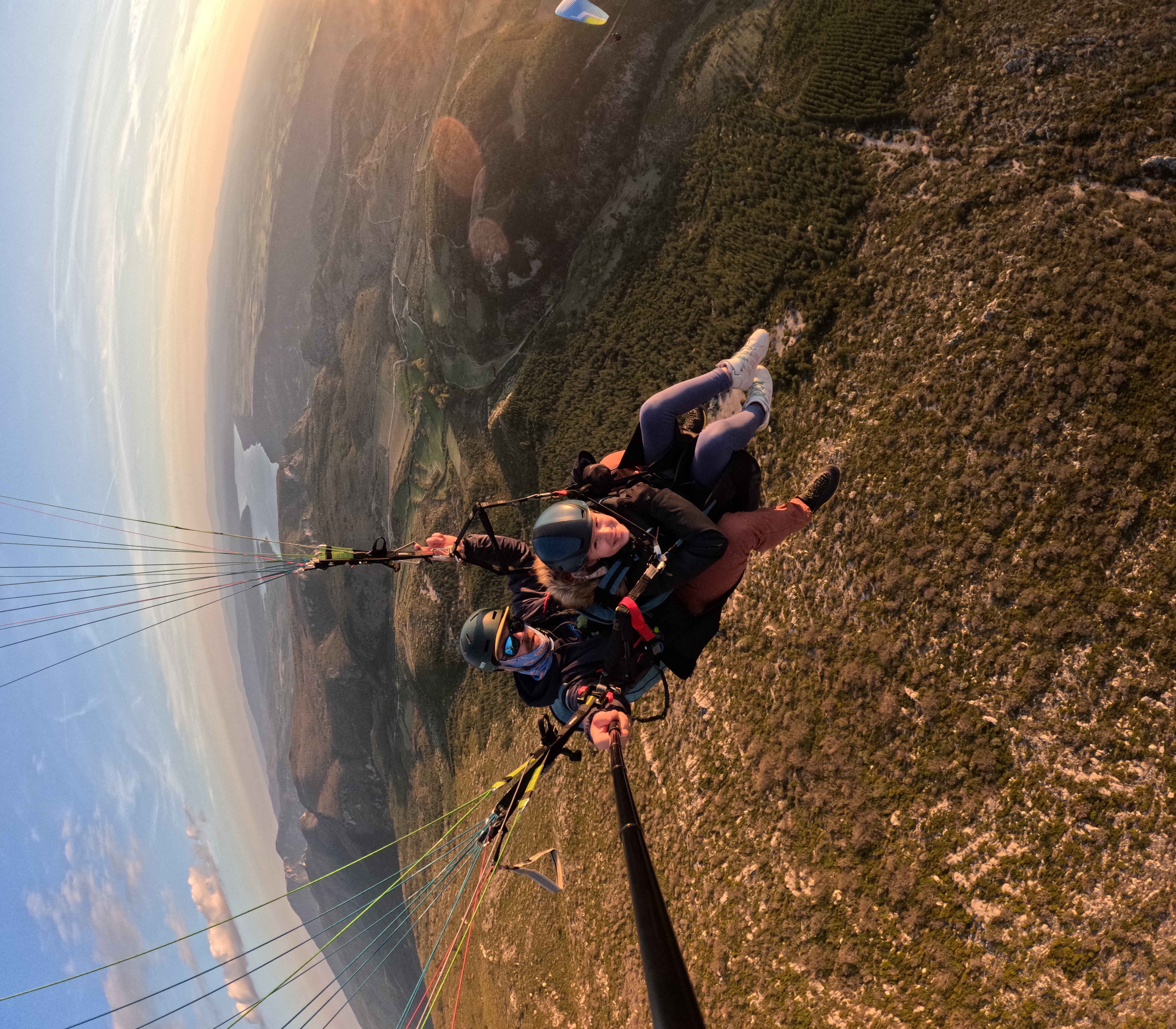 Passager profitant d’un vol en parapente biplace, détendu au-dessus des montagnes de Haute-Savoie