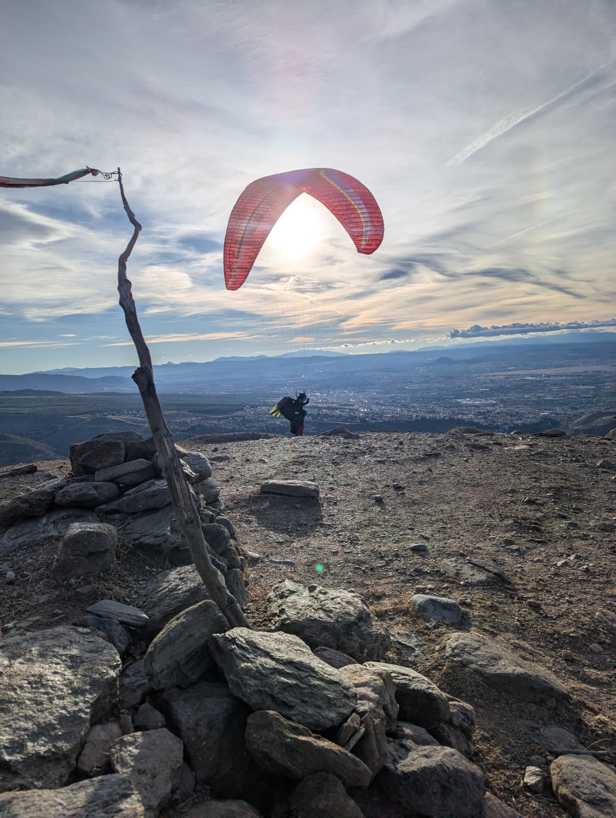 Décollage en parapente au coucher du soleil, avec Grenade en contrebas