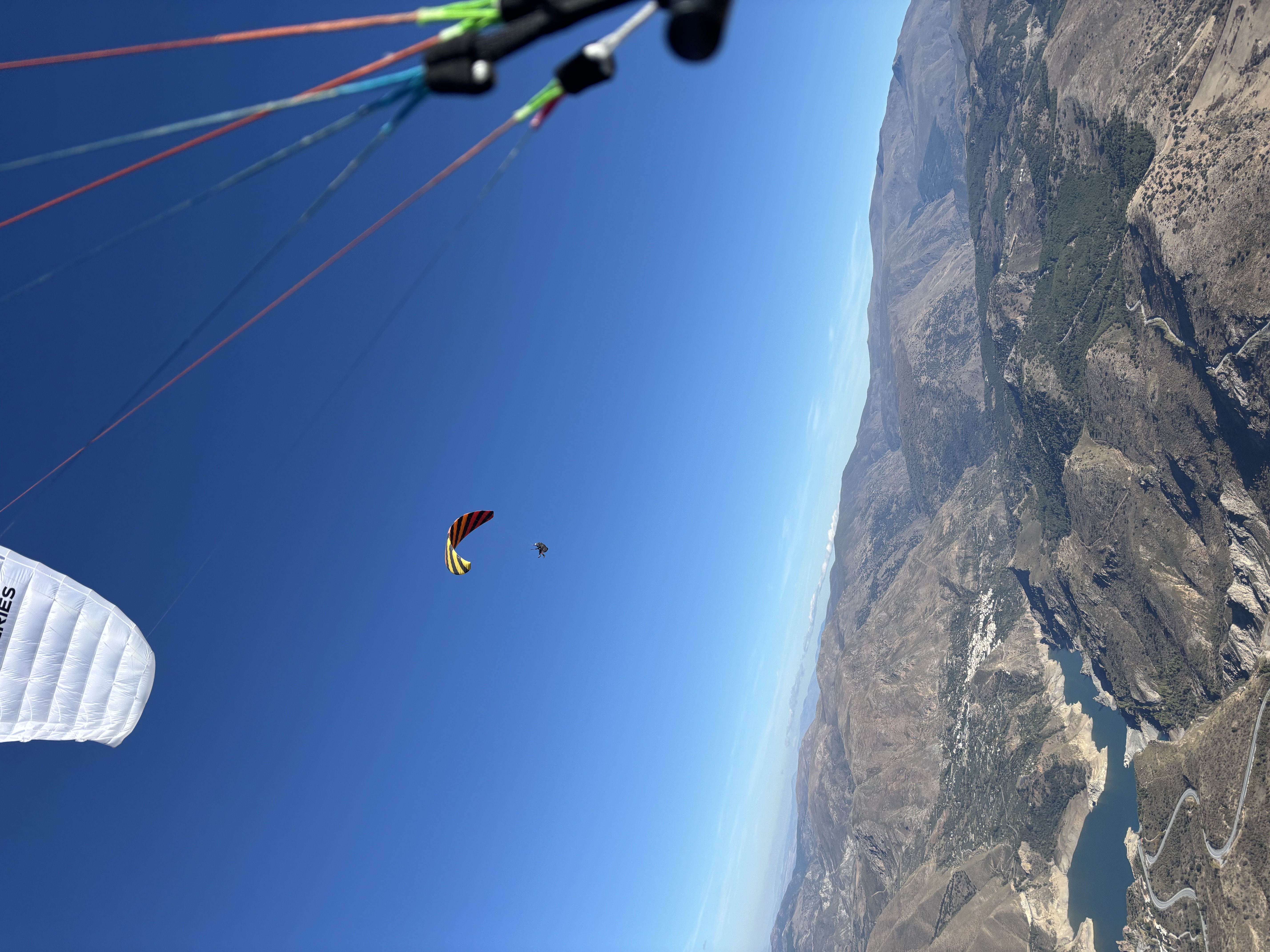 Paysage de retenue d’eau et de reliefs secs dans la Sierra Nevada, vu depuis un vol en parapente