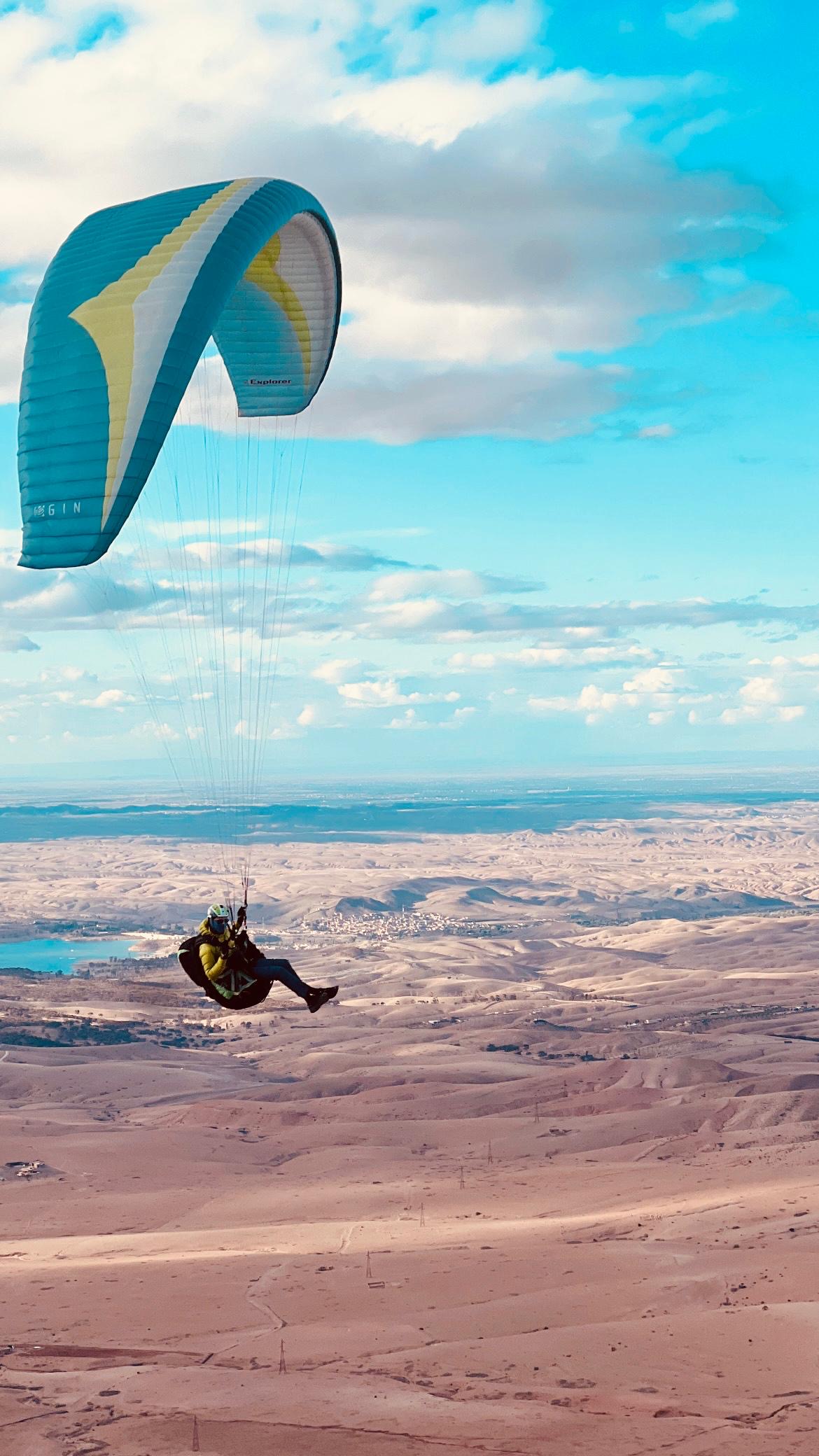 Pilote en vol thermique en parapente au-dessus des montagnes de l’Atlas marocain