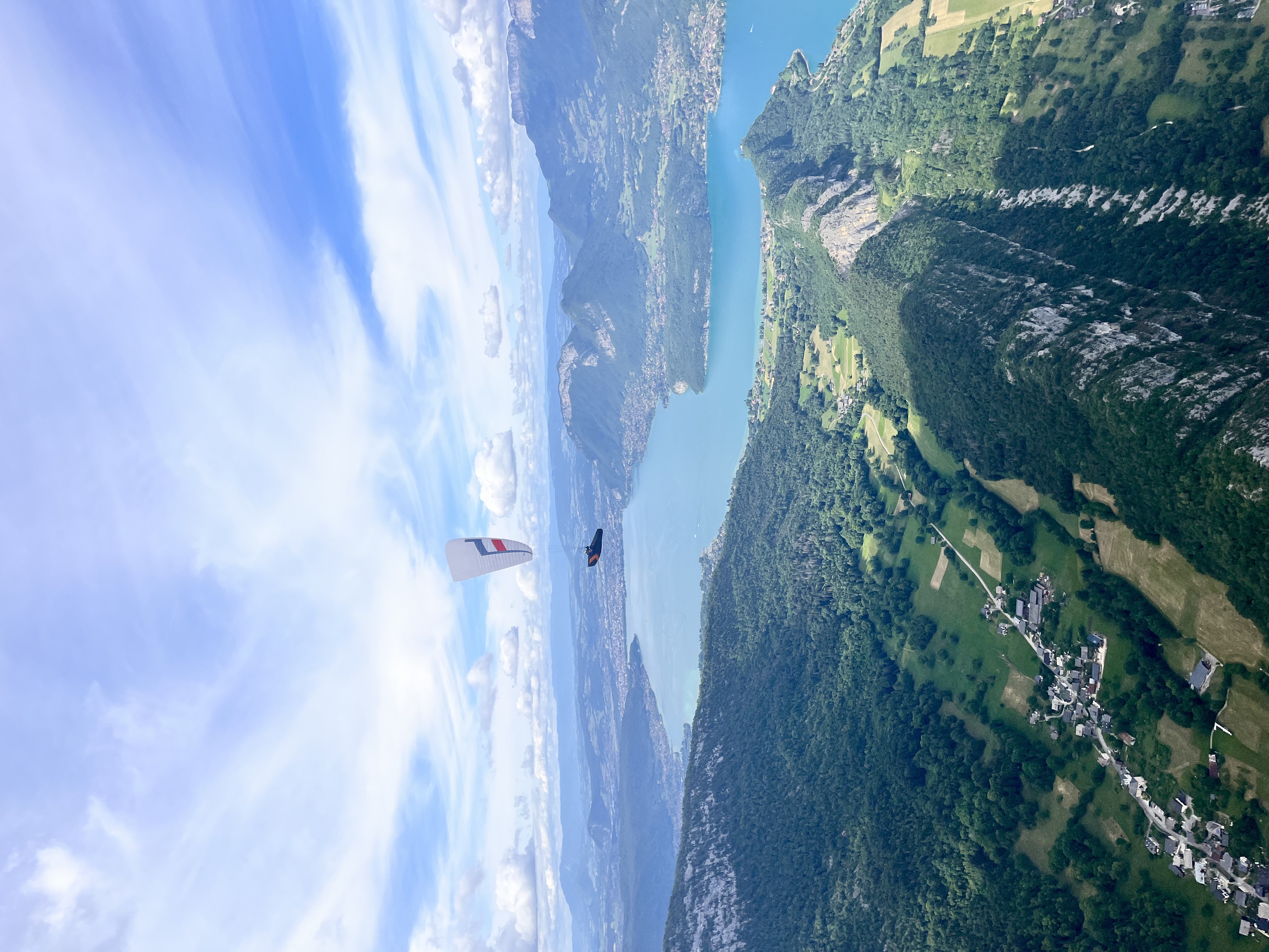 Pilote en vol thermique en parapente au-dessus du lac d’Annecy